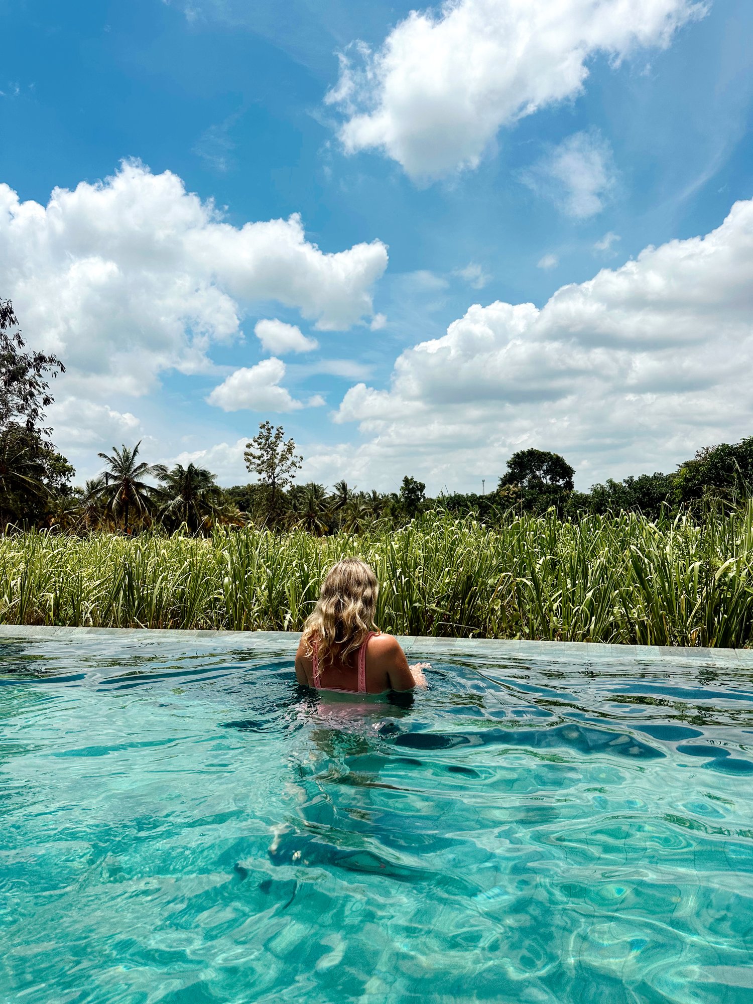 Evie in an infinity pool overlooking Balinese rice fields
